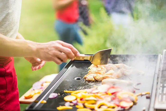 Plancha gaz extérieure, avec légumes et poulet.