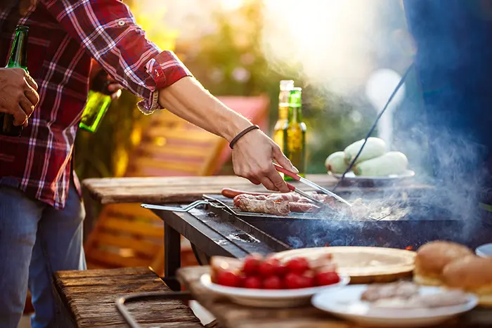 Personne qui cuisine autour d'une plancha.