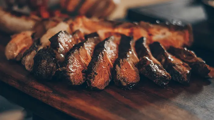 Viandes cuites dans une plancha en acier au carbone laminé.